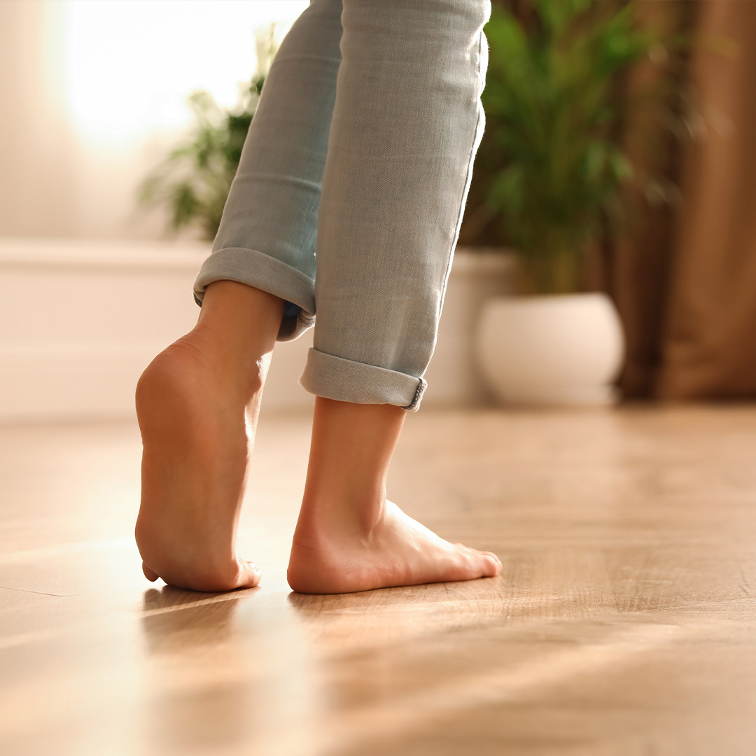 bare_feet_walk_san_lazzaro_city_green.jpg Persona che cammina scalza in casa su un parquet